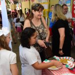 Famílias visitam os estandes da exposição da Semana Cultural