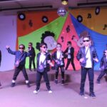 Alunos do Infantil II se apresentam no palco da formatura, com o tema Anos Dourados