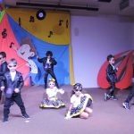 Alunos do Infantil II se apresentam no palco da formatura, com o tema Anos Dourados