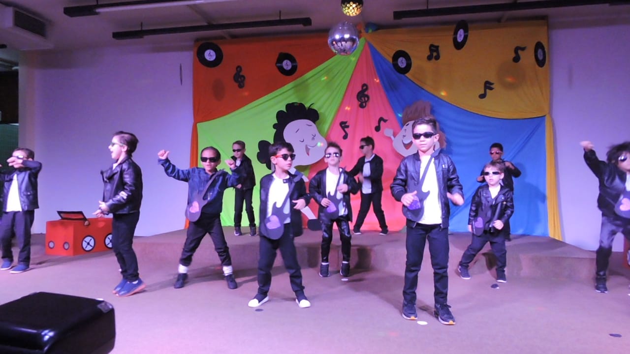 Alunos do Infantil II dançando no palco na formatura de 2019