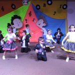 Alunos do Infantil II se apresentam no palco da formatura, com o tema Anos Dourados