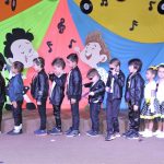 Alunos do Infantil II se apresentam no palco da formatura, com o tema Anos Dourados