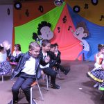 Alunos do Infantil II se apresentam no palco da formatura, com o tema Anos Dourados