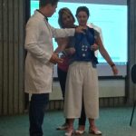 Instrutor demonstra uma manobra de desengasgo no treinamento de primeiros socorros