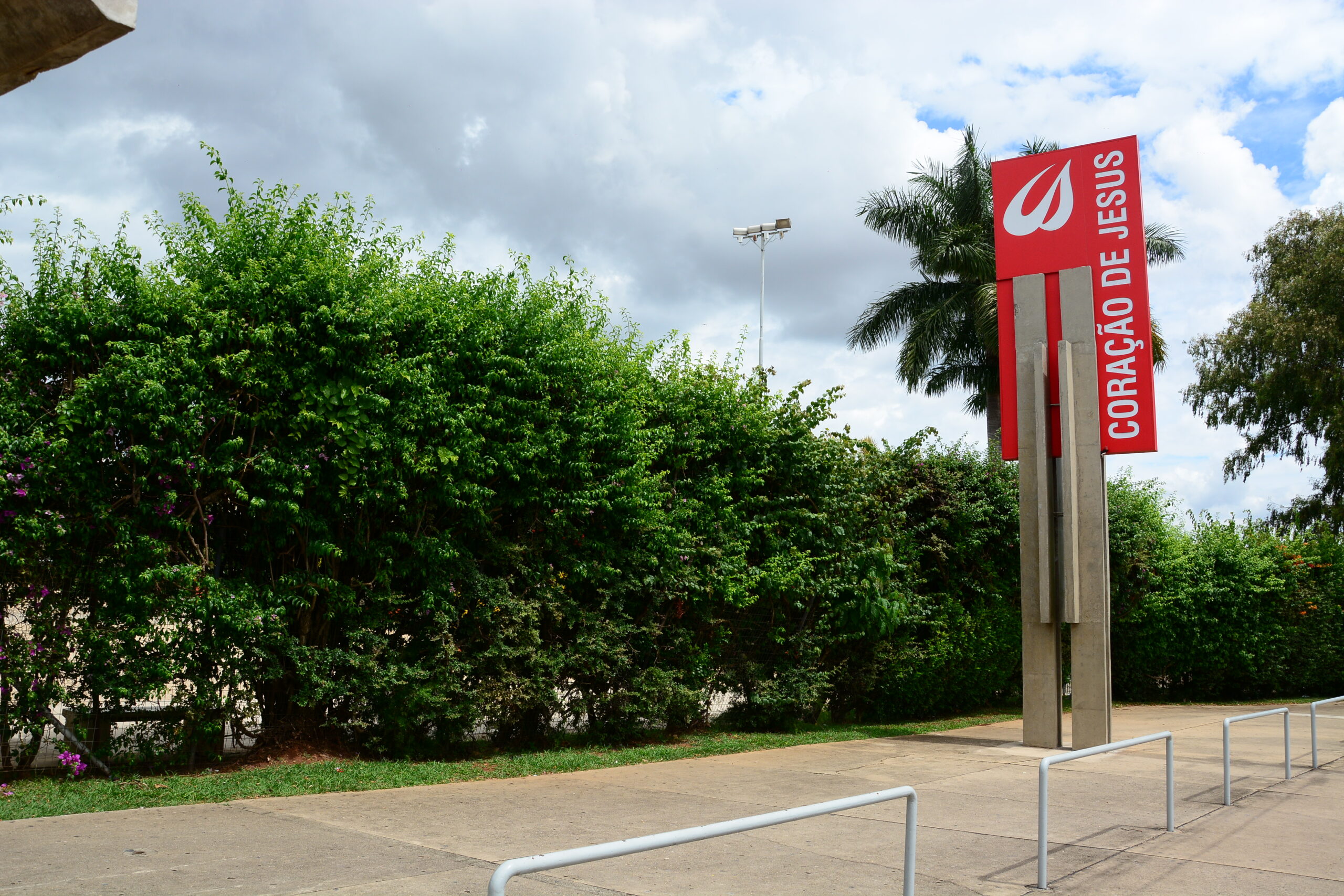 Totem com a marca do colégio na entrada, na apresentação da infraestrutura