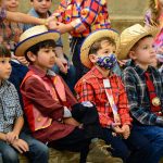 Participantes com trajes juninos posam para foto no Arraiá do Coração
