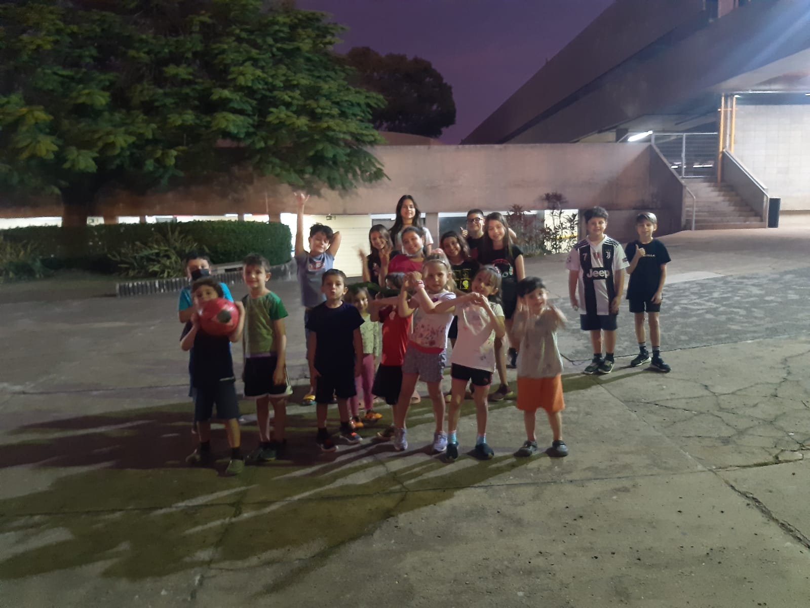 Crianças reunidas na área externa da escola durante as férias no período integral