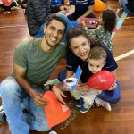 Mãe e filho sentados no chão do ginásio durante a homenagem do Dia das Mães