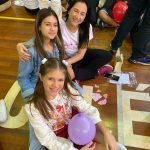 Mãe e filho sentados no chão do ginásio durante a homenagem do Dia das Mães