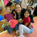 Mãe e filho sentados no chão do ginásio durante a homenagem do Dia das Mães