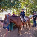 Aluno da Educação Infantil monta a cavalo na visita ao Sítio São José