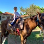 Aluno da Educação Infantil monta a cavalo na visita ao Sítio São José