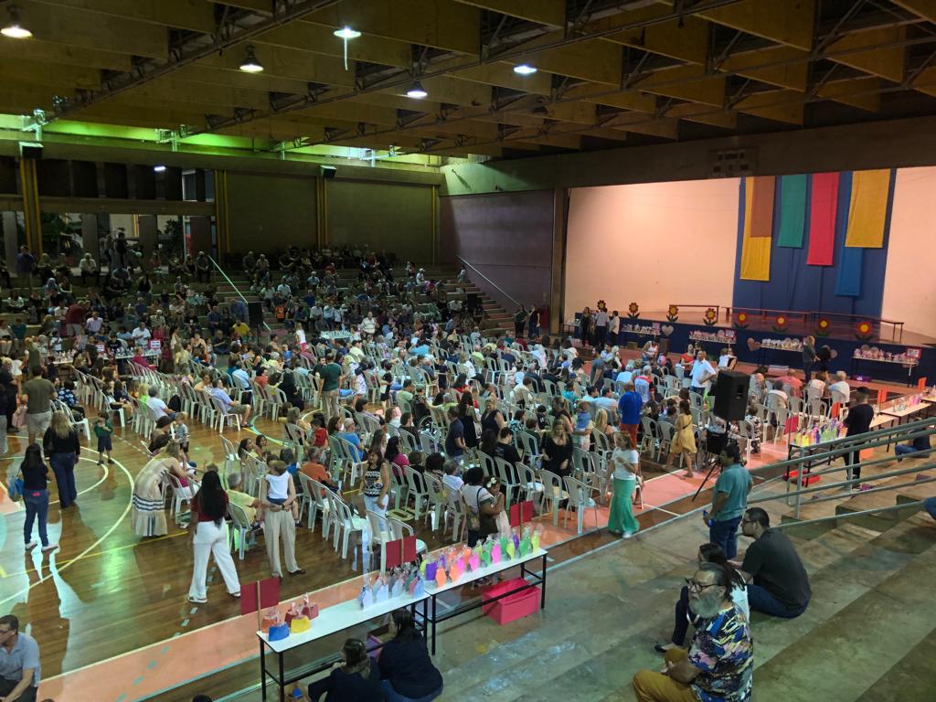 Ginásio com famílias e alunos reunidos no Momento de Gratidão aos Avós