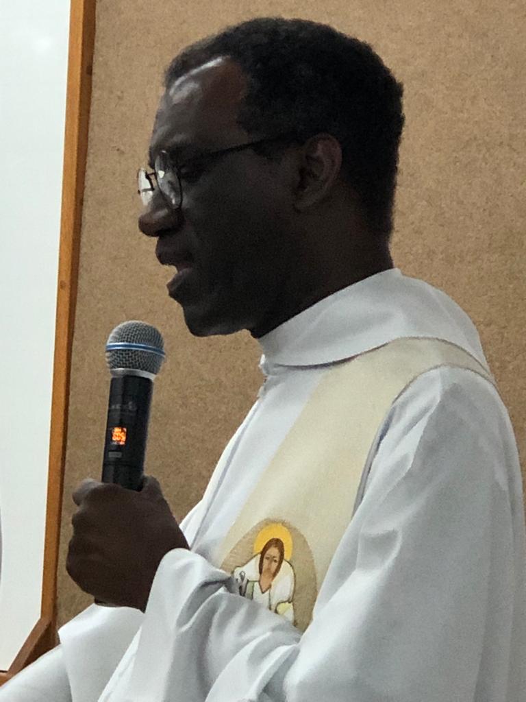 Padre falando ao microfone na celebração do Dia de Nossa Senhora do Calvário