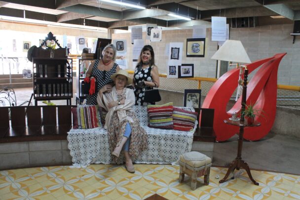 Cenário montado com poltrona vermelha e quadros na Mostra Cultural