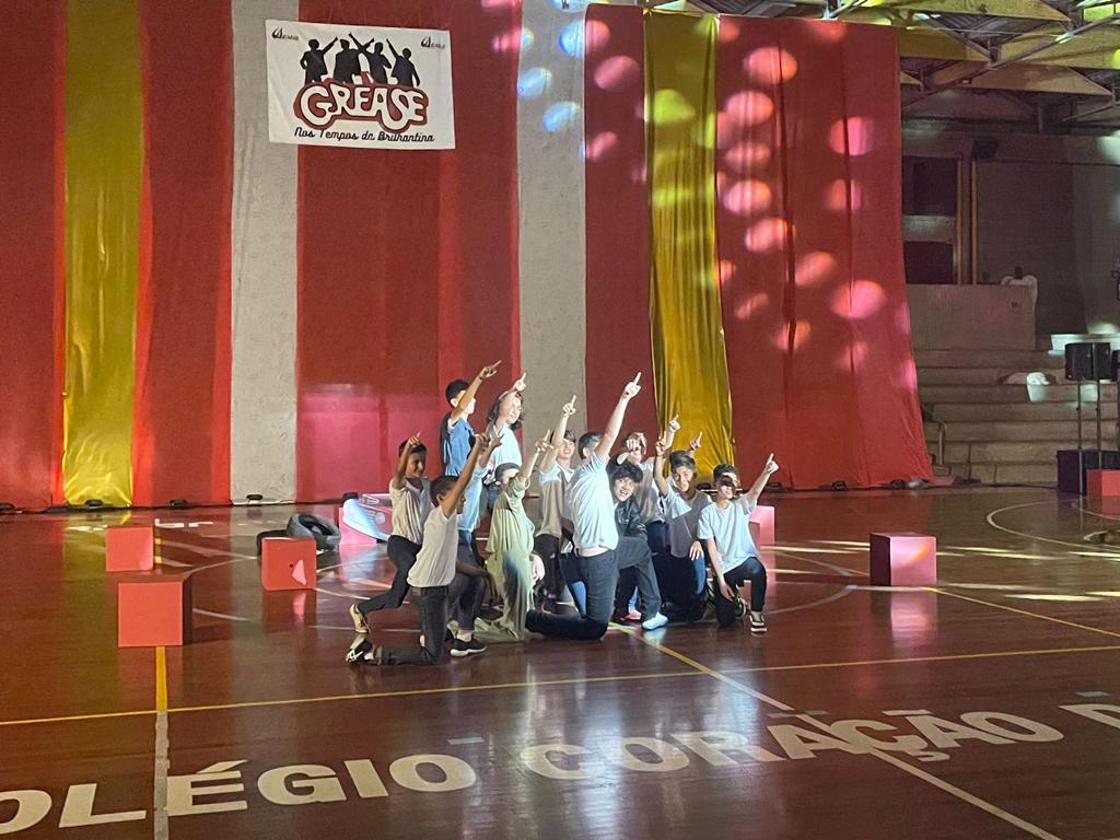Alunos no palco do ginásio na apresentação do musical Grease, nos Tempos da Brilhantina