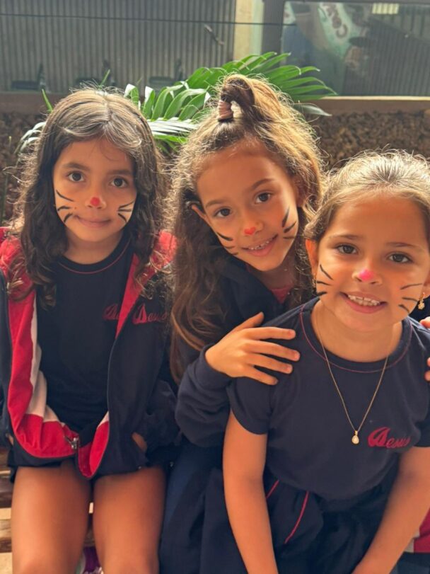 Três meninas com o rosto pintado de coelhinho na comemoração de Páscoa