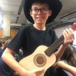 Aluno com chapéu e violão se prepara para a apresentação no Show de Talentos