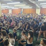 Plateia de alunos assiste às apresentações do Show de Talentos