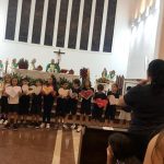 Coral dos alunos canta diante do altar na celebração do Mês de Maria