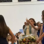 Coroação da imagem de Nossa Senhora, com alunos reunidos ao redor