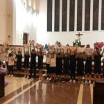 Coral dos alunos canta diante do altar na celebração do Mês de Maria
