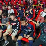 Crianças assistem ao filme na sessão de cinema do Férias no Coração