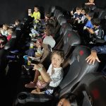 Crianças assistem ao filme na sessão de cinema do Férias no Coração