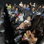 Crianças assistem ao filme na sessão de cinema do Férias no Coração