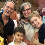 Avós e netos abraçados e sorrindo durante a Homenagem aos Vovós