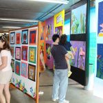 Corredor com painéis de trabalhos dos alunos na Mostra Cultural