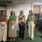 Professores perfilados no auditório, sendo apresentados às famílias na 1ª Reunião de Pais