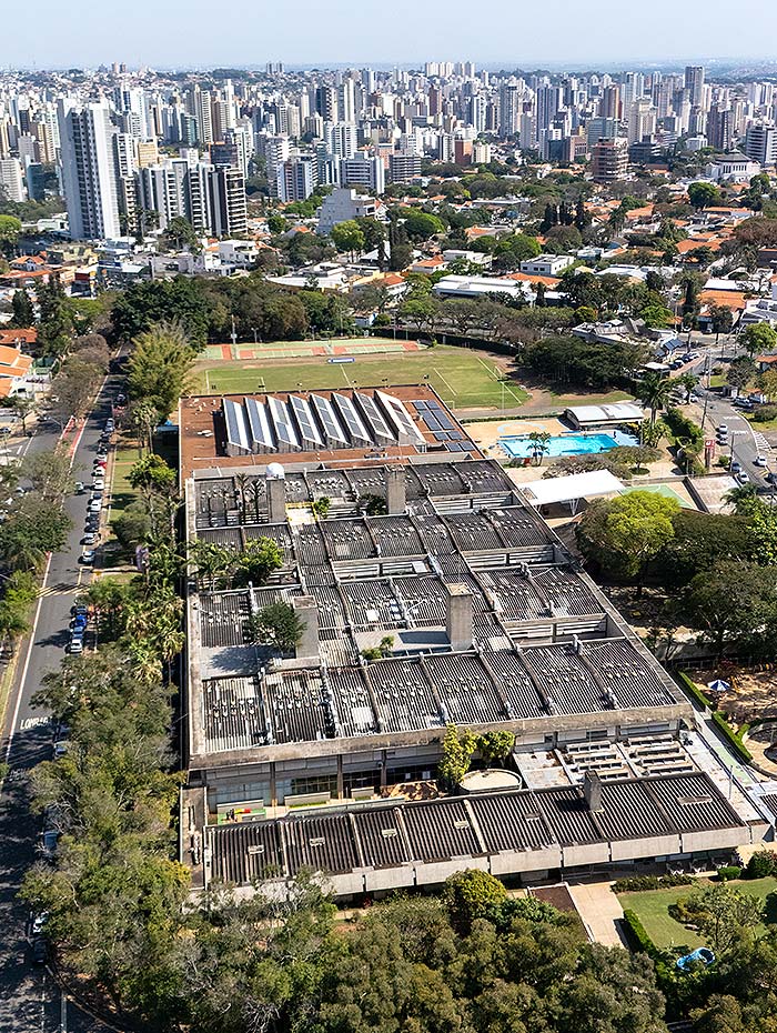 Vista aérea do colégio no Parque Nova Campinas, com os prédios e as quadras em primeiro plano e a cidade ao fundo