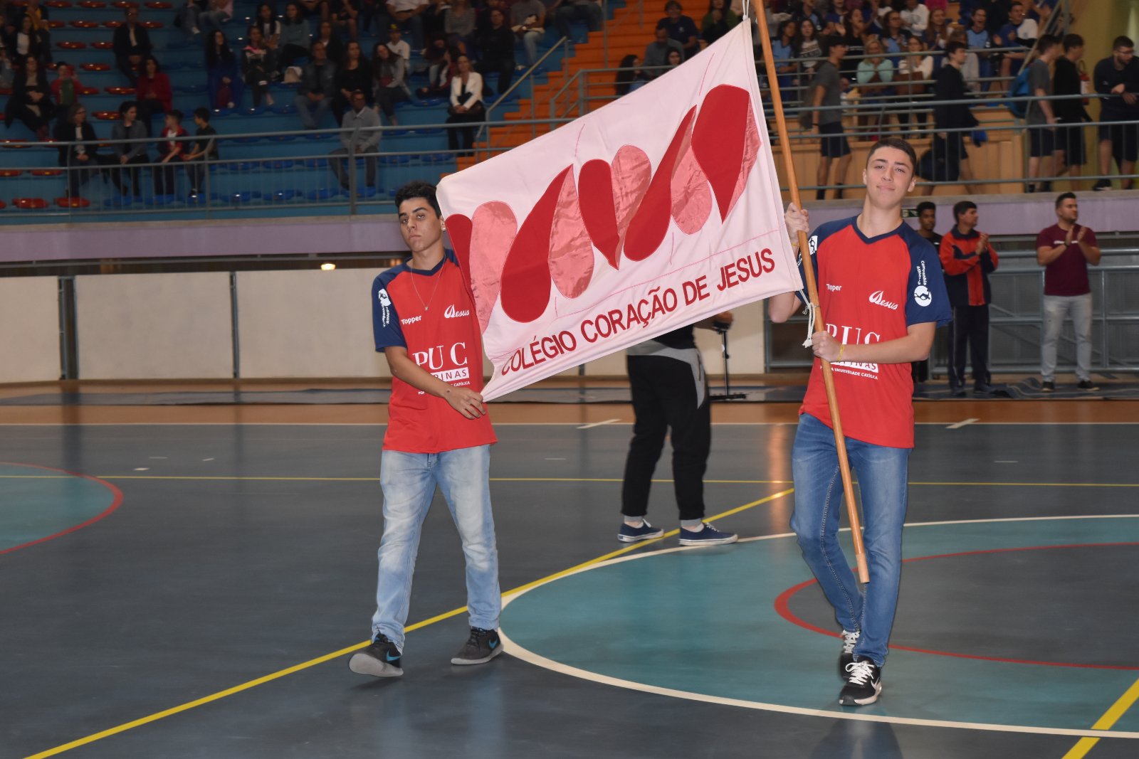 Dois alunos do Colégio Coração de Jesus carregam a bandeira da escola na quadra durante a abertura dos 2º Jogos Escolares Intercatólicas